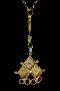 ROMAN GOLD PENDANT WITH FAIENCE: Ca. 400 ADA gold pendant in upside down "V" shape, the rim is decorated with filigree which roles elegantly along the top, the centre has filigree in the shape of three diamonds which central