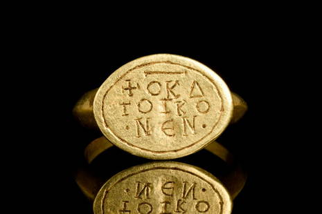 BYZANTINE RELIGIOUS GOLD SIGNET RING: Ca. 600-800 ADA Byzantine gold ring featuring a discoid bezel joined to a solid round-section hoop and decorated with a religious inscription in Greek.Following the trends set by the Romans,