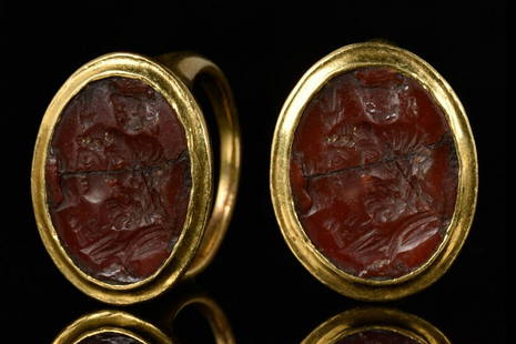 ROMAN GOLD RING WITH CARNELIAN INTAGLIO ISIS AND SERAPIS: Ca. 100-200 ADA finely modelled gold ring with tapering band, the bezel oval in shape, depicting Serapis wearing the modius (corn measure) expressing his role as guarantor of the fertility of Egypt.