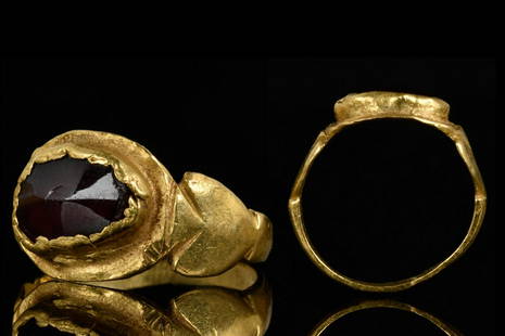 ROMAN GOLD FINGER RING WITH CABOCHON GARNET: Ca. 3rd Century ADA finelly modelled gold ring, that possibly of a child, formed of a flat tapering band with scrolled form around the bezel. The bezel is raised and set with a cabochon garnet.For