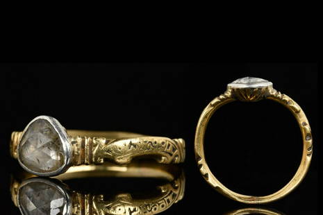 POST MEDIEVAL GOLD RING WITH DIAMOND: Circa 1800 AD A slender gold ring with teardrop-shaped bezel decorated with a sparking diamond. The band with ribbed decoration and with an inscription. Size: D: 15.8mm / US: 5 1/8 / UK: K; 3.7g