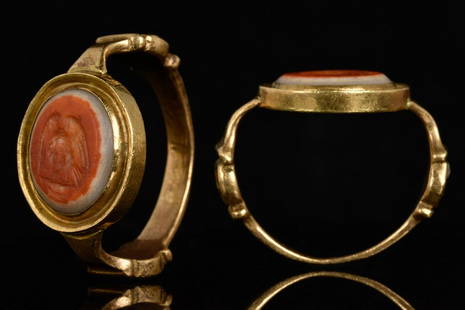 ROMAN EAGLE BANDED AGATE GOLD RING: Ca. 100-200 ADA gold ring with oval banded agate gem depicting an eagle standing on a nest, its wings deployed, eatting a hare. The shoulders of the ring are wide and have decorative scrolls on both