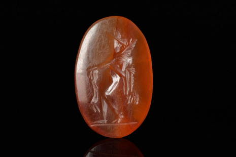 ROMAN CARNELIAN INTAGLIO DEPICTING A GENIUS: Ca. 100-300 ADAn oval shaped intaglio with a genius presiding spirit that brings good fortune. He is carrying a cornucopia and the hand is outstretched to make an offering.Henig M. & MacGregor A.;