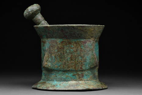FATIMID BRONZE PESTLE AND MORTAR: Khorosan, Afganistan or Egypt Ca. 12th century AD A heavy bronze mortar and pestle. The mortar comprises an out-turned rim, a cylindrical body decorated with pyramidal bosses, and a stepped-out foot.