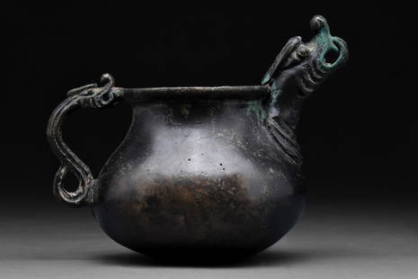 SAFAVID BLACK POTTERY JUG WITH DRAGON-HEADED HANDLE AND SPOUT: Persia or Central Asia, Ca. 16th century AD A rare cast bronze jug of a globular body, resting on a flattened base, gently tapering from the mid-body to a short cylindrical neck with a flared rim. The