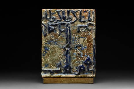 SELJUK OR ILKHANATE TILE FRIEZE: Kashan, Ca. 12th-13th century AD A rectangular-shaped pottery tile with a brown ground decorated with a dotted and vegetal motifs and navy glazed calligraphy in relief. This tile, which would have