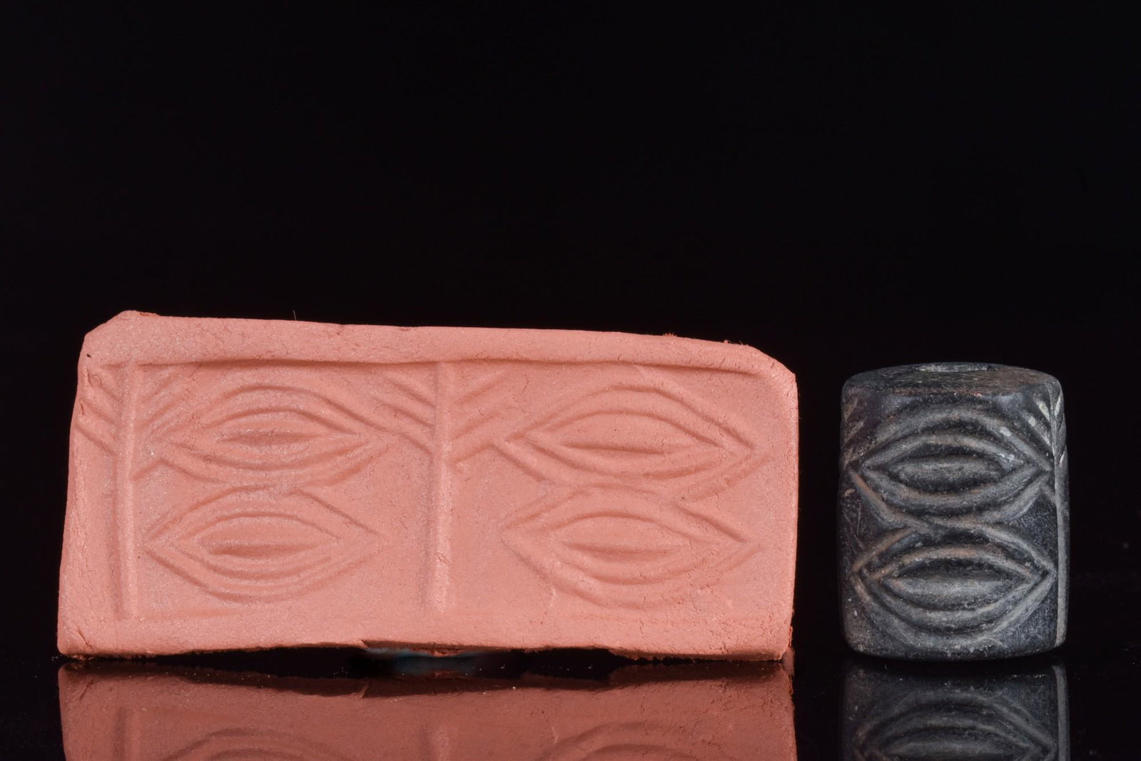 MESOPOTAMIAN CYLINDER SEAL - ORIGINAL LAMBERT REPORT: Ca. 3000 BC.Cylinder seal of black stone. Two pairs of two eye shapes are separated by a tree at each end. Condition fine. Accompanied by a signed scholarly note by Professor Wilfrid George Lambert.Si