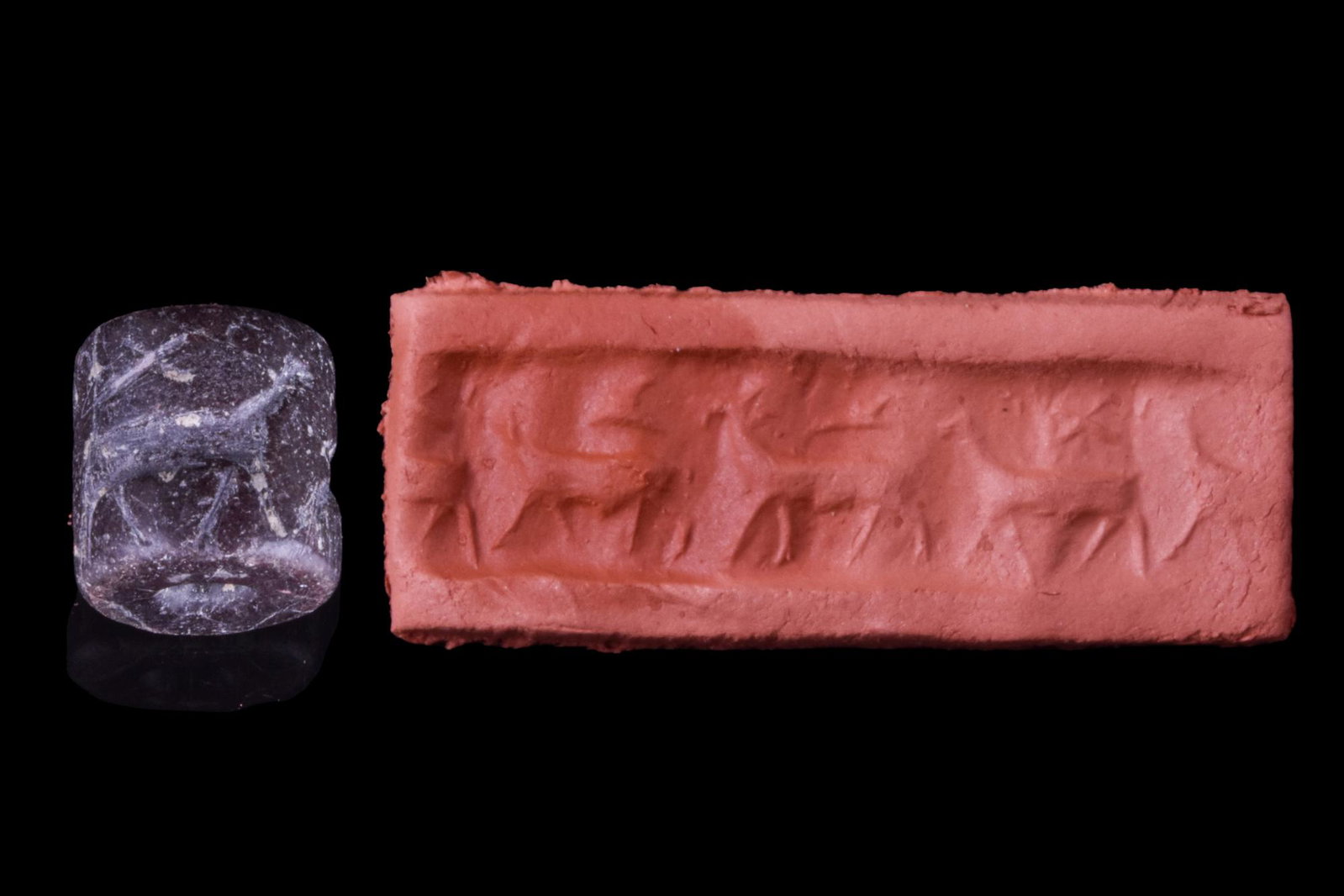 MESOPOTAMIAN BLACK STONE CYLINDER SEAL WITH ANIMALS - ORIGINAL LAMBERT REPORT: Ca. 3000 BC. Cylinder seal of black stone. Frieze of three waking quadrupeds with items above their backs. Condition fair. Accompanied by a signed scholarly note by Professor Wilfrid George Lambert. S