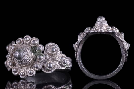 ELABORATE BYZANTINE SILVER RING: Ca. 600-800 AD. A silver finger ring featuring a ribbed hoop with an applied bezel with intricate knobbed filigree decoration and captivating shoulders embellished with trefoil plaques that mirror the