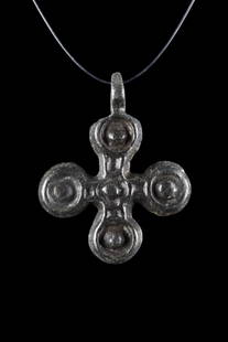 BYZANTINE BRONZE CROSS PENDANT: Ca. 1000-1300 AD. A cruciform pendant crafted from bronze features four circular terminals with a raised dot at the center of each. A suspension loop at the top provides a perfect finishing touch. The