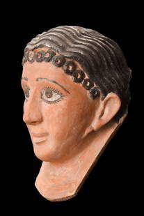 EGYPTIAN POLYCHROME MASK: Roman Period, ca. 30 BC - 323 AD. A moulded ceramic funerary mask of a wealthy Romano-Egyptian female. The mask showcases elaborate arrangements of black painted hair, meticulously crafted to evoke