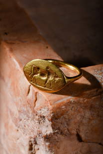 GREEK HELLENISTIC GOLD RING WITH A BULL: Ca. 500-400 BC. A beautiful gold finger ring with a pointed lozenge-shaped bezel and a round-section hoop. The bezel is skilfully engraved with a depiction of a right-facing bull. The lines of the