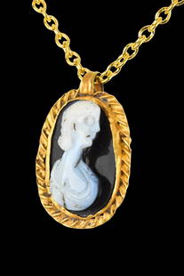 STUNNING ROMAN GOLD AND SARDONYX CAMEO PENDANT WITH JULIA DOMNA: Ca. 200 AD. A gold ovoid pendant with a suspension loop and a rope-patterned border enclosing a white on black sardonyx cameo depicting a bust of Julia Domna, the Roman empress from 193 to 211 as