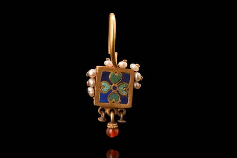 BYZANTINE ENAMELLED AND JEWELLED GOLD EARRING: Ca. 800 AD.A stunning gold earring with a central square-shaped plaque, which is the focal point of the piece. It is adorned with a stunning quatrefoil design highlighted in green and cobalt blue enam