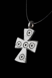 BYZANTINE BRONZE CROSS PENDANT WITH FIVE WOUNDS OF CHRIST: Ca. 600-800 AD.A bronze cross pendant with flaring terminals and concentric circles motif at the junction and each arm. The five wounds of Christ motif represented in this pendant has a rich and compl
