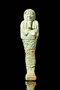 EGYPTIAN FAIENCE USHABTI: Late Period, Ca. 688-332 BC.An ancient Egyptian faience ushabti of a mummified form, standing on a plinth. He is depicted wearing a tripartite wig and a false beard. The hands protrude from the