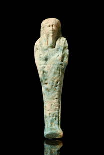 EGYPTIAN FAIENCE USHABTI: Late Period, Ca. 688-332 BC.An ancient Egyptian faience ushabti of a mummified form, standing on a plinth. He is depicted wearing a tripartite wig and a false beard. The hands protrude from the