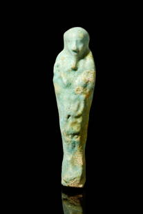 EGYPTIAN FAIENCE USHABTI: Late Period, Ca. 688-332 BC.An ancient Egyptian faience ushabti of a mummified form, standing on a plinth. He is depicted wearing a tripartite wig and a false beard. The hands protrude from the chest,