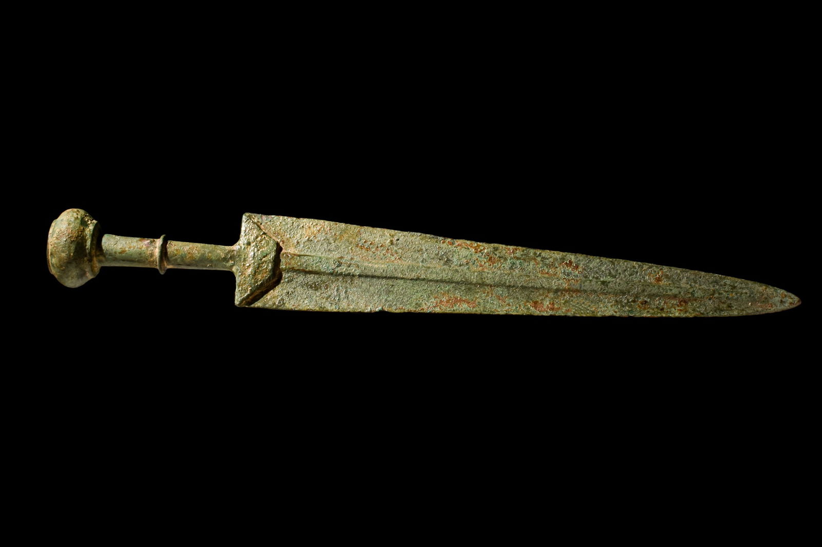 ANCIENT BRONZE SWORD: Western Asiatic/Aegan, Ca. 1200-700 BC.A bronze short sword featuring a solid-cast guard and a triangular blade with mid-rib and sharp edges tapering to a point. The hilt is modelled in the round and