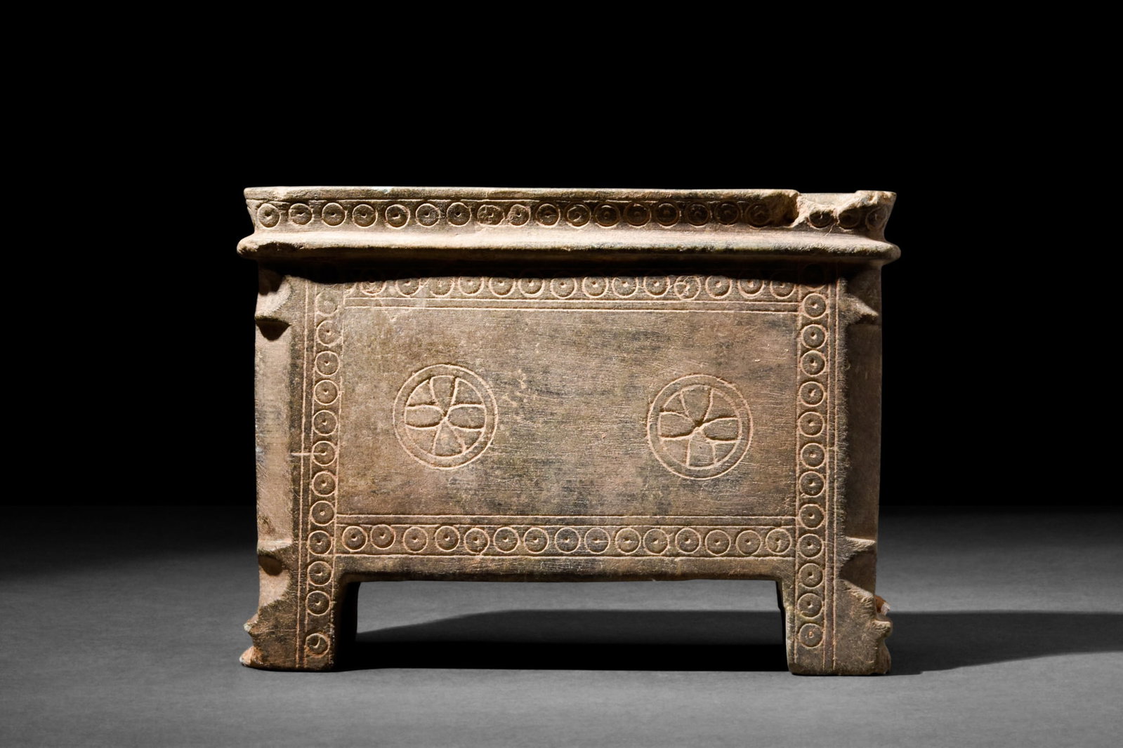 RARE GANDHARAN SCHIST STONE RELIQUARY: Ca. AD 200-300.A rare schist stone reliquary box of a cuboid shape on four, irregularly shaped legs; with rounded corners and pronounced flange below a slightly flaring rim. Decorated with a concentri
