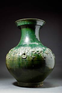 CHINESE HAN DYNASTY GREEN GLAZED POTTERY HU JAR: Possibly Han Dynasty, Ca. 202 BC - AD 220.A stunning Chinese Han Dynasty Hu jar that is covered in a thick lead based green glaze. The vessel has a flat base, with rounded sides and a tall cylindrical