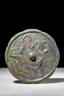 CHINESE TANG DYNASTY BRONZE MIRROR WITH DRAGON: Possibly Tang Dynasty, Ca. AD 618-907 or later.A bronze mirror featuring a round-shaped body with a central raised boss. The reverse side depicts a three-clawed dragon striding amidst four vaporous cl