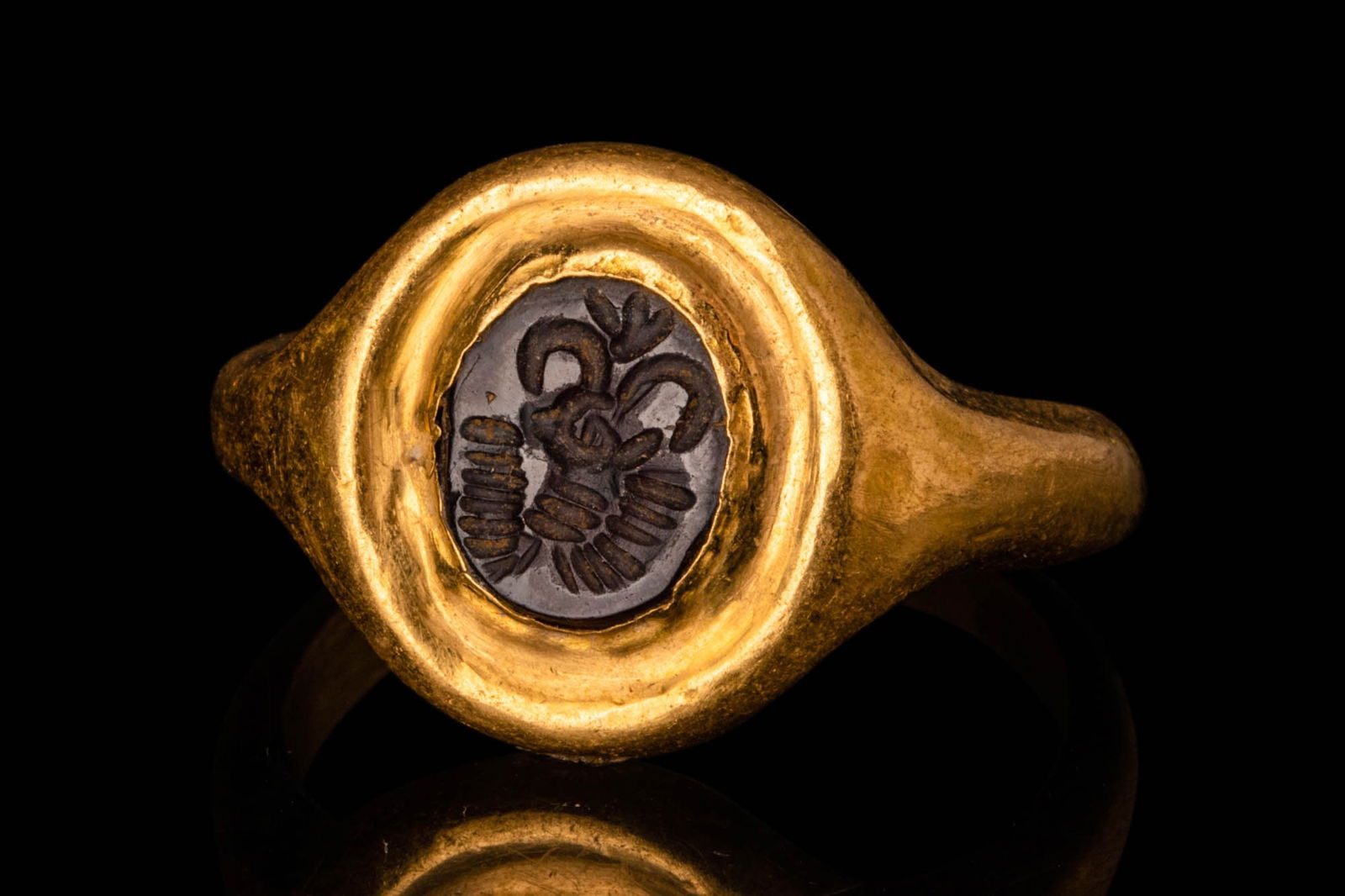 SASANIAN GOLD FINGER RING: Ca. AD 224 - 651. A Sasanian 20.5 ct gold finger ring with an intaglio depicting a stag with long curved horns. The intaglio is set in a gold bezel, attached to a round, D-section hoop. For similar se