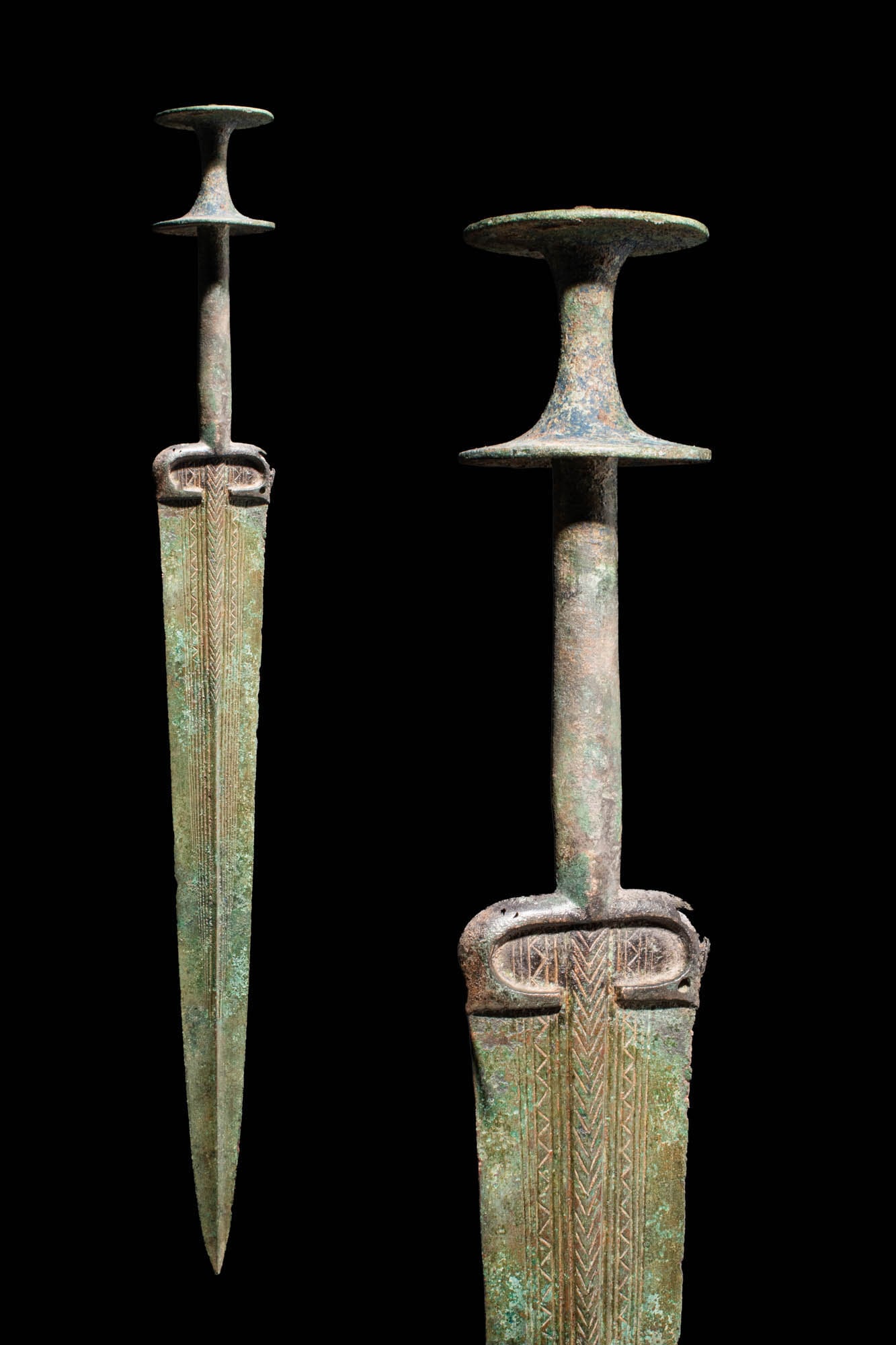 ANCIENT BRONZE SWORD WITH DOUBLE POMMEL: Ca. 1000 - 800 BC An early Bronze Age sword with a long tapering blade featuring a raised mid-rib and a curved decoration on the top of the handle. The hilt has a round-section shank, and the sword ha