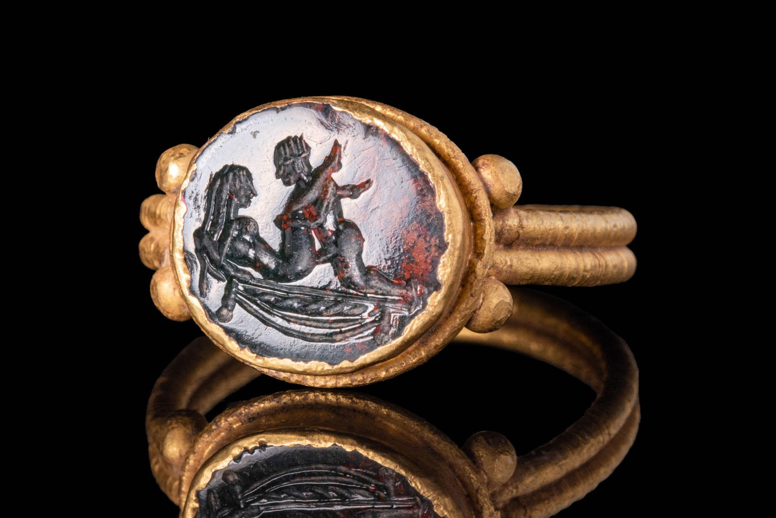 ROMAN JASPER INTAGLIO WITH EROTIC SCENE IN GOLD RING: Ca. AD 100 - 300A Roman round jasper intaglio depicting an erotic scene. The design is made in stylised manner typical of the second century when the intaglio rings became popular in the army of the R