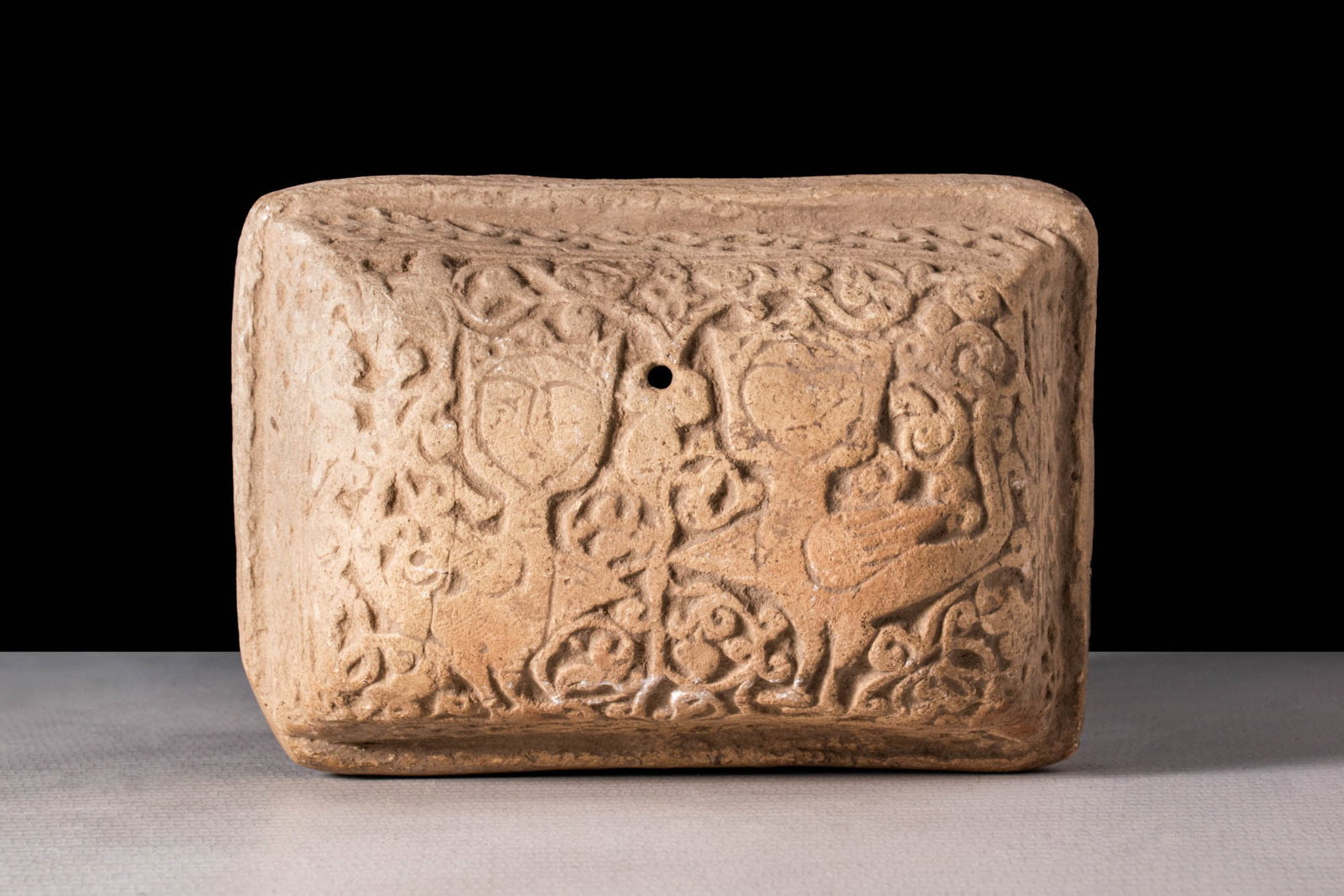 SAFAVID POTTERY LID OF BOX WITH MYTHOLOGICAL ANIMALS: Ca. AD 1400 - 1600A Safavid pottery lid of a box decorated with floral and geometric motifs within two mythological figurines composed of a bird body and a human haed, the back side is decorated with 