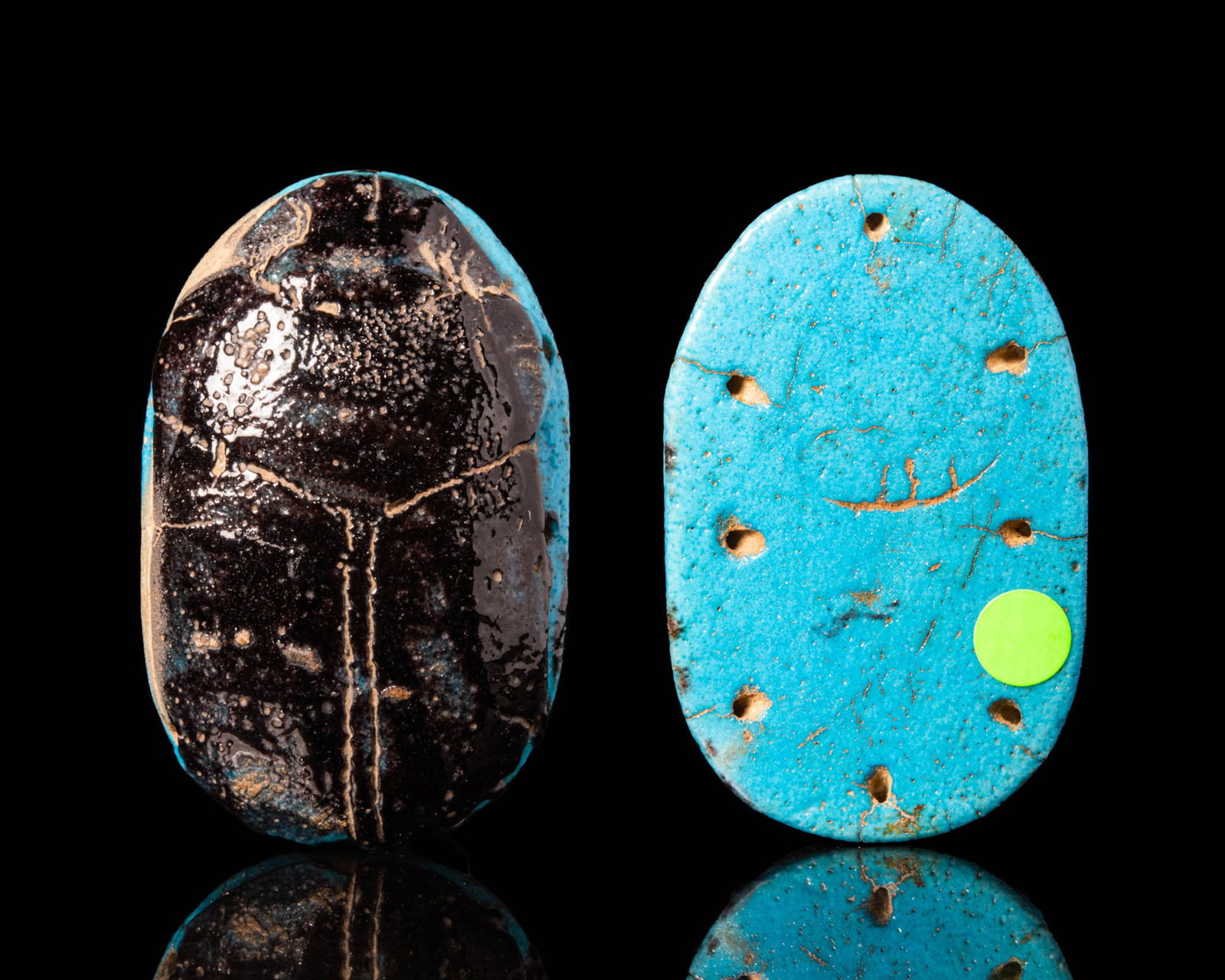 EGYPTIAN FAIENCE FUNERARY SCARAB: New Kingdom, Ca. 1550 - 1069 BC.A stunning funerary scarab made of two coloured Maiolica. The top displays characteristic insectile features, such as a miniscule head, thin folded legs underneath a la