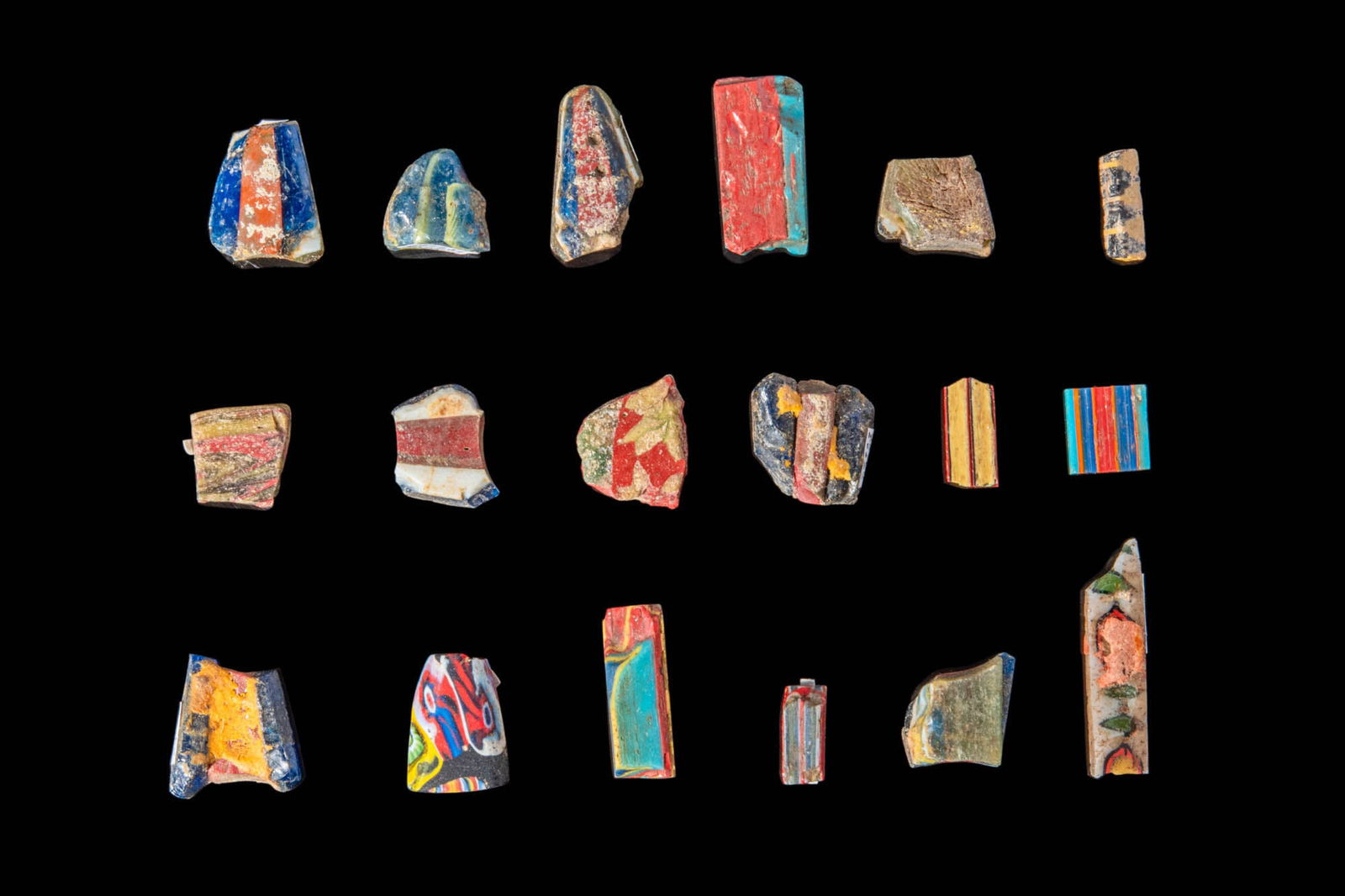 SET OF ROMANO - EGYPTIAN MOSAIC GLASS INLAYS: Ca. 30 BC - AD 200.A set of 18 mosaic glass inlays, all of various sizes and shapes, primarily polychrome. These inlays are originating from architectural tiles.Size: 12.5-27.3mm x 4.1-6.7mm; Weight: