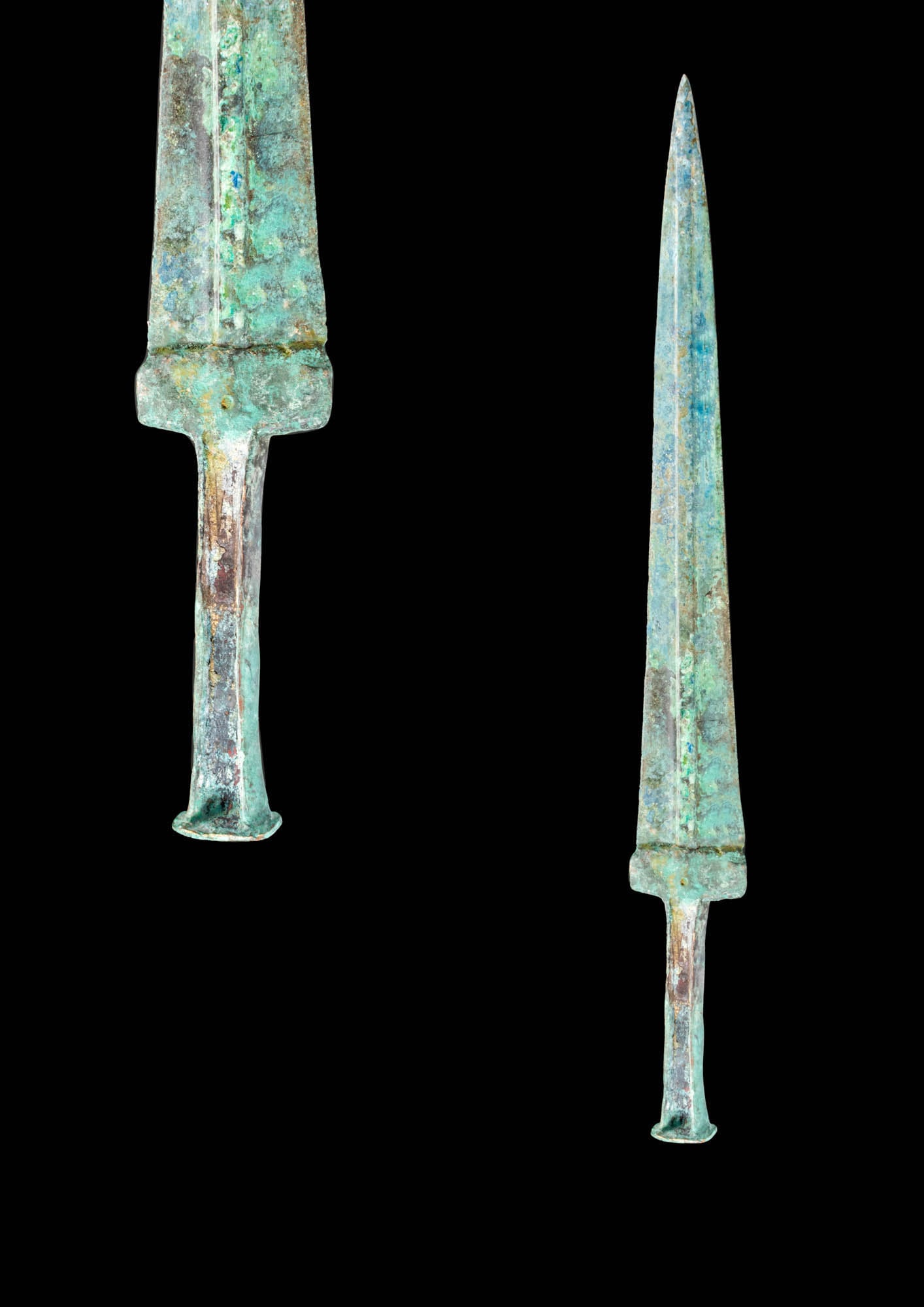 EARLY GREEK / WESTERN ASIATIC BRONZE SWORD: Ca. 1100 - 900 BC.A moulded bronze dagger with a short, tapering blade, a prominent midrib and a guard. The hilt is characterised by a flat hollow cross-section that would fix to a wooden or bone hand