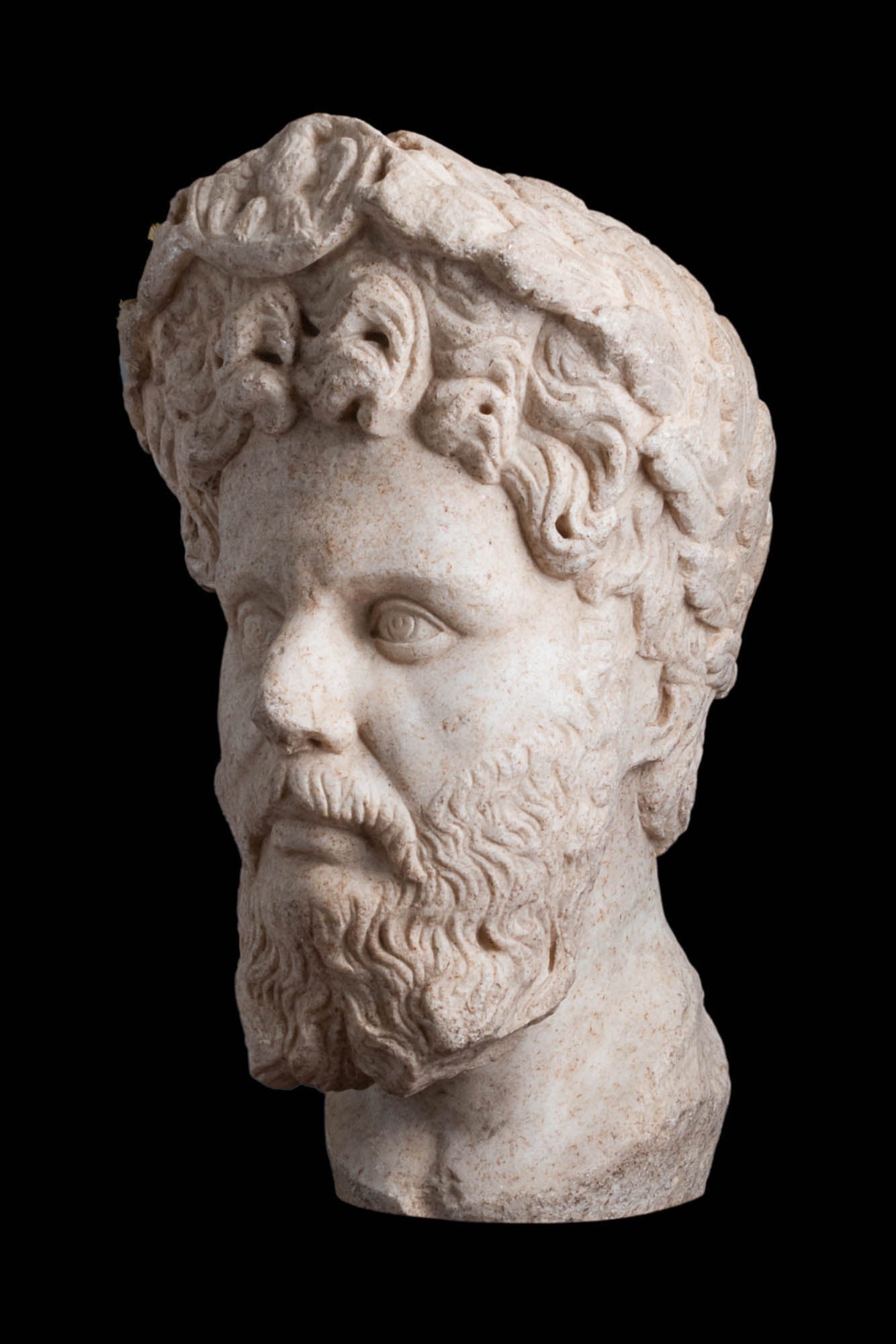 ROMAN MARBLE HEAD OF SEPTIUMIUS SEVERUS: Ca. AD 193 - 211 .A Roman over the life-sized head of Septiumius Severus depicted facing forward with the thick curling hair falling in four pronounced curls over the brow, the characteristic long par