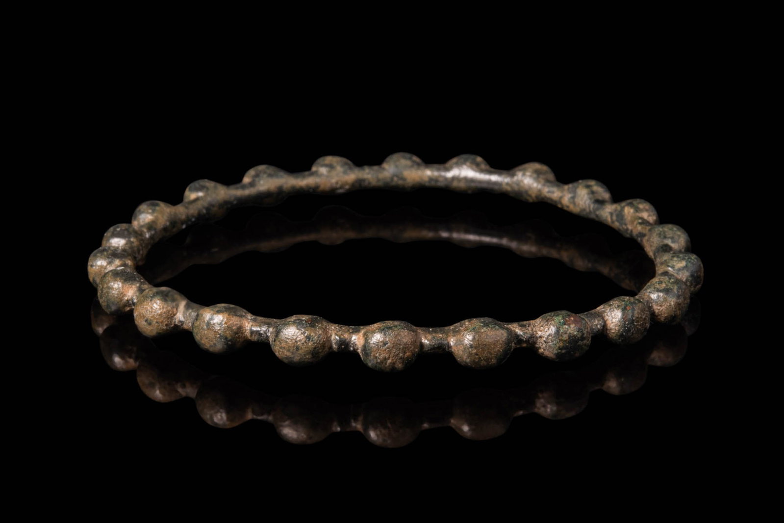 CELTIC BRONZE BRACELET WITH SPHERES: Ca. 300 - 100 BC. A bronze bracelet with a continuous series of evenly spaced, rounded spheres forming the outer surface.For similar see: The British Museum, Museum number ML.1567, 1880,0802.137.Size: