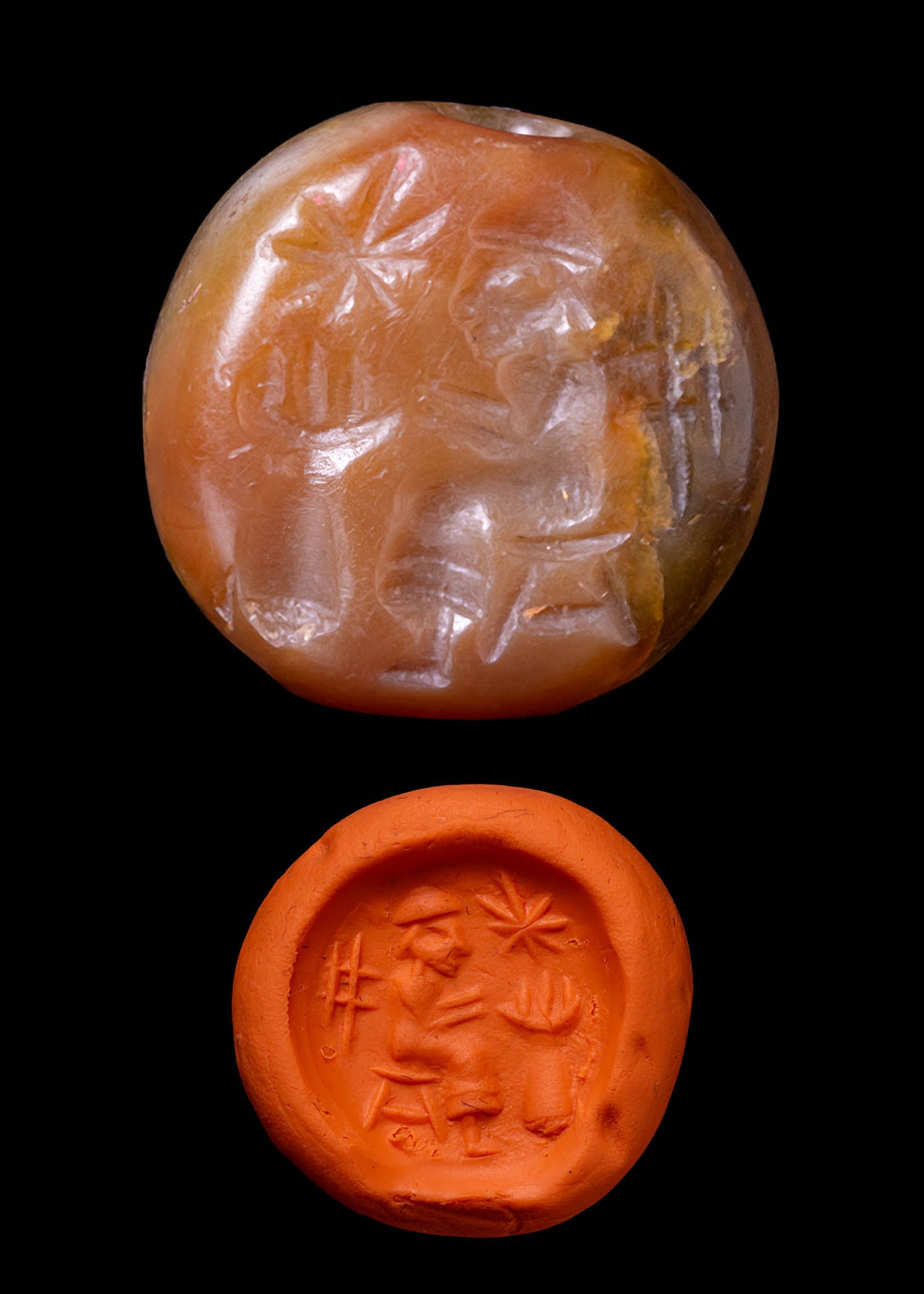 SASSANIAN CARNELIAN SEAL WITH WORSHIPPER AND GOD: Ca. AD 200 - 600. A domed carnelian seal with convex upper side and central perforation. The flat surface is engraved with a scene showing a seated worshipper facing an altar with a large eight-pointe