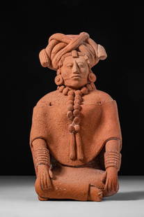 MAYAN FEMALE FIGURE - ex. CHRISTIE'S: Jaina, Late Classic, Ca. AD 550 - 950. A terracotta female figure seated with legs crossed and arms extended downward, the hands resting symmetrically on the knees. The figure wears a fitted garment w