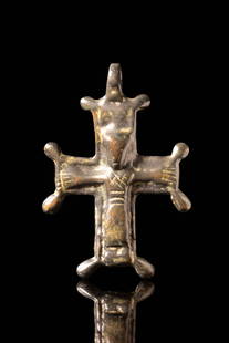 BYZANTINE BRONZE CROSS PENDANT: Ca. AD 900 - 1100. A bronze cross pendant cast in relief with the figure of the crucified Christ. The arms of the cross terminate in rounded, expanded ends, and the upper section is surmounted by an i