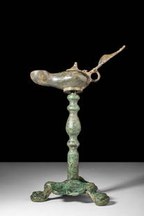 BYZANTINE BRONZE OIL LAMP AND THREE LEGS STAND: Ca. AD 400 - 600. Ca. AD 400 - 700A cast bronze oil lamp sitting atop a decorative tripod stand. The lamp itself is the quintessential magic lamp, with a rounded body and elongated spout. A small hing