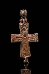 BYZANTINE BRONZE RELIQUARY CROSS WITH CRUCIFIX: Ca. AD 900 - 1100. A reliquary consisting of two crosses that fit together and a large loop for suspension. The front cross is incised with busts of saints at the top of each arm and an angel in the c