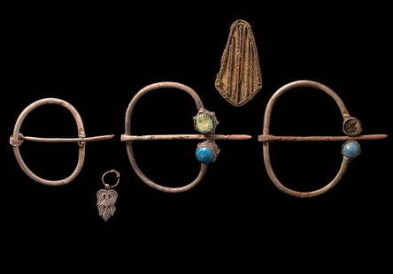 COLLECTION OF VIKING BROOCHES AND PENDANTS: Ca. AD 800 - 1300. A collection of ornaments including three oval brooches, two of which are set with blue inlays, a trapezoidal ribbed appliqué with ropework decoration and a small, silver pendant.F