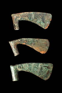 COLLECTION OF EARLY GREEK / BRONZE AGE AXE HEADS: Ca. 1200 - 900. A collection of three socketed bronze axe heads of similar form, each with a short cylindrical socket and a flaring arched blade. The cutting edge is curved, and both sides of the blad