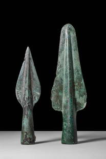PAIR OF EUROPEAN BRONZE AGE SPEARHEADS: Ca. 1800 - 1200 BC. A pair of bronze spearheads, each cast with a prominent central midrib running from the socket to the tip. The sockets are cylindrical with slightly flaring mouths. Both blades tap