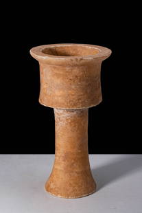 BACTRIAN ALABASTER CHALICE: Ca. 2200 - 1800 BC. A tall alabaster vessel with a wide cylindrical cup with a gently everted rim, rising from a long, slender stem that flares into a broad, circular base. The stone exhibits layered