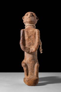 SOUTH ARABIAN FUNERARY FIGURE: Ca. 100 - 1 BC. A funerary figure shown standing upright with short, slightly bowed legs, elongated arms meeting at the front with incised fingers, and a flattened rectangular torso. The head is propo
