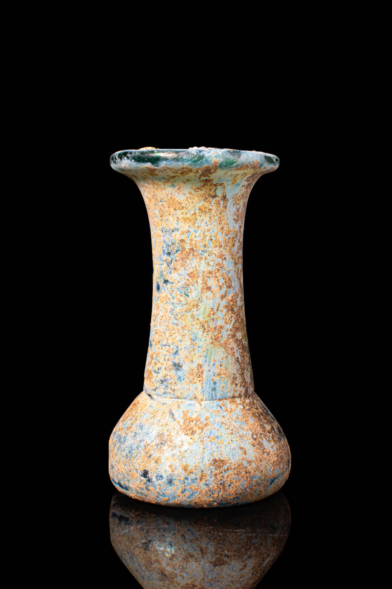ROMAN GLASS UNGUENTARIUM: Ca. AD 1 - 200. A blue-green glass unguentarium with a compact body and convex sides. The long, cylindrical neck rises to a wide, outwardly flaring rim with a folded lip. For similar see: C. S. Lightf