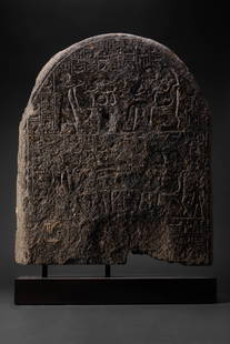 LARGE EGYPTIAN GRANITE FUNERARY STELA OF THE LECTOR-PRIEST BAKY AND HIS WIFE RUIU: New Kingdom, XVIIIth Dynasty reign of Thutmose III, Ca. 1504-1450 BC . A very rare black granite round topped funerary stela of the ' third lector-priest, pure of hands in the temple of Montu ', 'Over