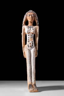 RARE EGYPTIAN PAINTED TERRACOTTA FERTILITY FIGURE: Middle Kingdom, 13th Dynasty, Ca. 1803 - 1649 BC. A painted terracotta figure depicting a standing female with elongated proportions. The face is framed by a thick wig painted in alternating black, wh