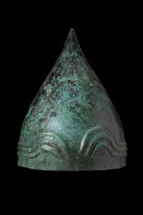 RARE URARTIAN BRONZE HELMET: Ca. 800 - 700 BC. A helmet hammered from a single bronze sheet, conical in shape, with three horizontal raised ribs encircling the lower edge. The front is decorated with a repoussé triple-arched rib