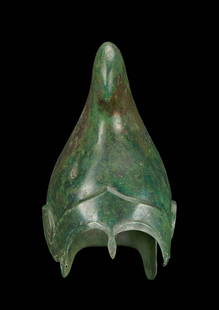 RARE PHRYGIAN-CHALCIDIAN BRONZE HELMET WITH NASAL GUARD: Ca. 400 - 300 BC. A very rare hybrid helmet showing design characteristics of both Phrygian and Chalcidian helmets. The looped top of the helmet, hammered from a single piece of bronze, is clearly Phr